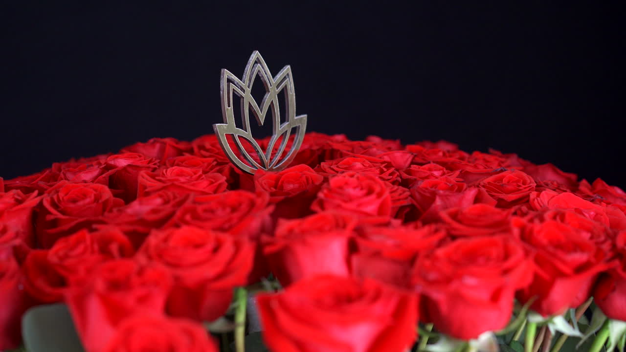 황금 연꽃 장식 검은 배경으로 회전하는 빨간 장미가 총을 닫습니다