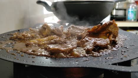 marinated lamb sizzles on a flat griddle, releasing a delicious, mouth-watering aroma. the cooking process creates an enticing scene for food lovers.