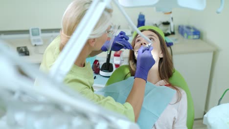 dentista perforando el diente enfermo de una paciente. estomatólogo usando un taladro dental