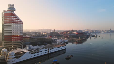 tram travelling at gotaalvbron bridge with p-arken ship on harbour beside lilla bommen building at sunrise in gothenburg, sweden