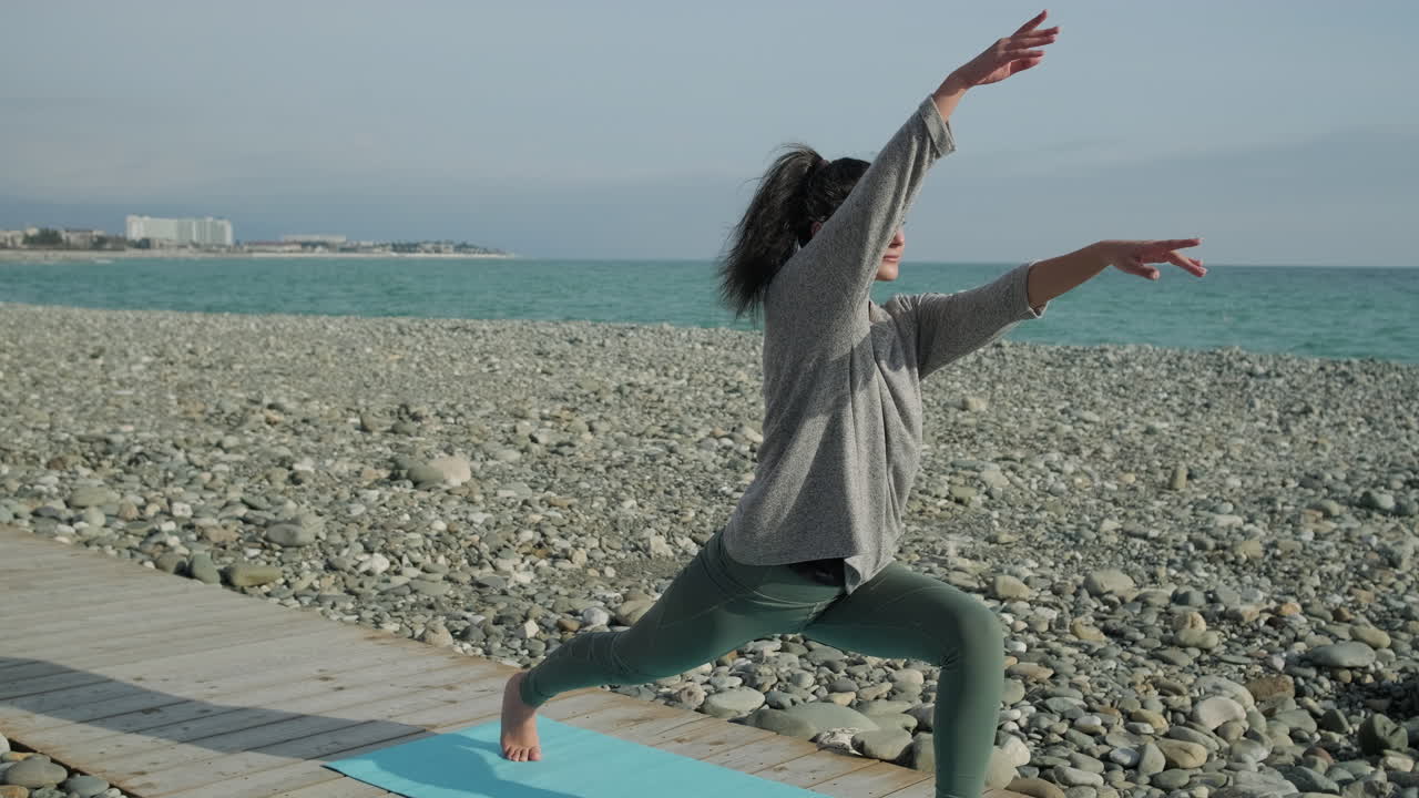 해변 에서 요가 를 연습 하는 여자