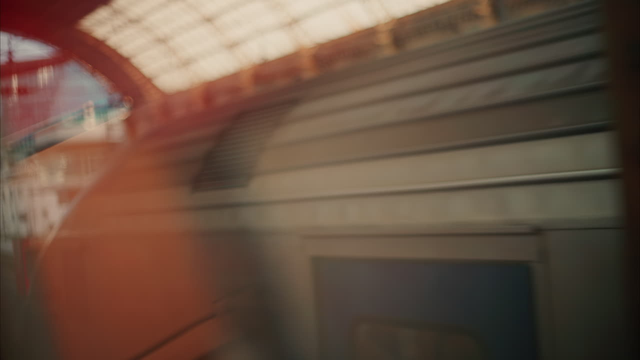 Close up of the seats near the window of a moving train with a view of the train station