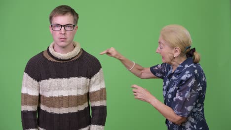 angry grandmother talking with unconcerned grandson and shrugging