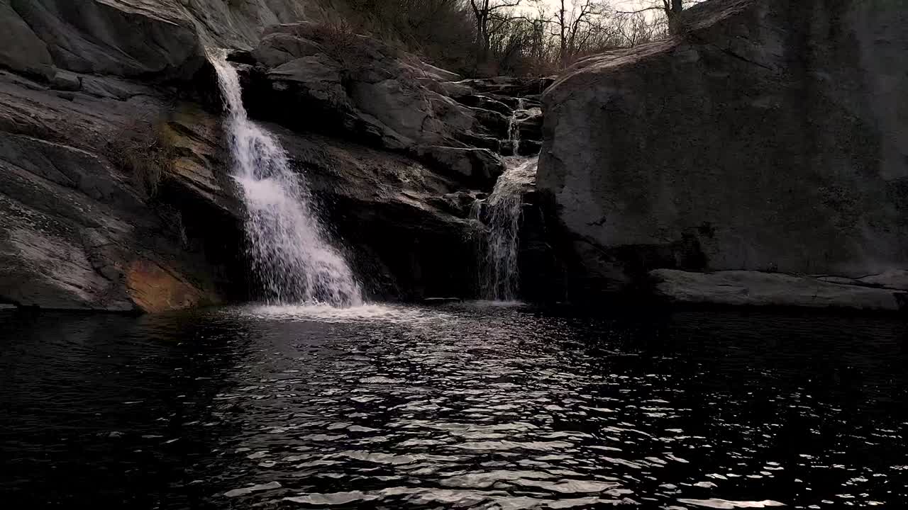 vuelo de avión no tripulado lateralmente sobre algunas piedras y una cascada durante el día cerca