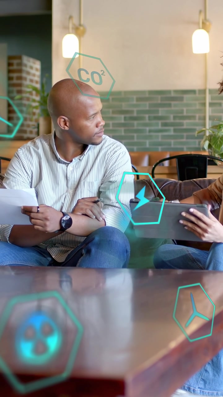 Vertical video: Woman tapping tablet causing man checking wrist while AR hex icons guiding biz plan