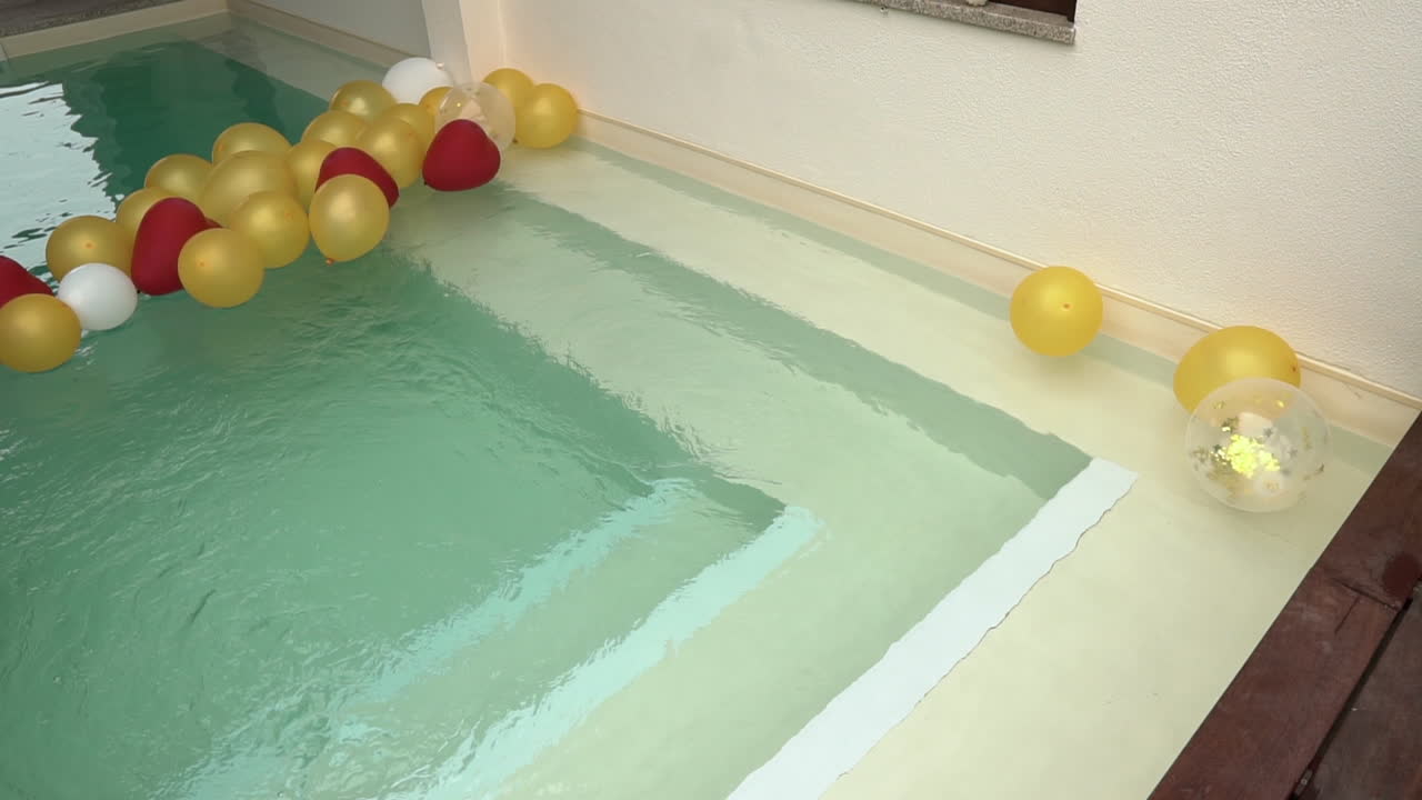 Stairs to a swimming pool filled with ballons. Party