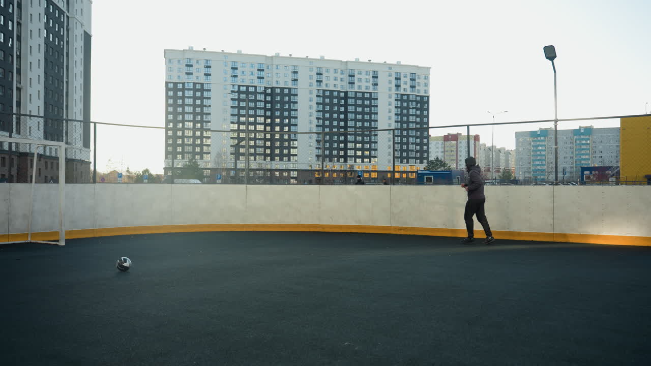 Athlete jogging in outdoor sport arena surrounded by urban high-rise buildings, emphasizing movement, energy, and modern city lifestyle
