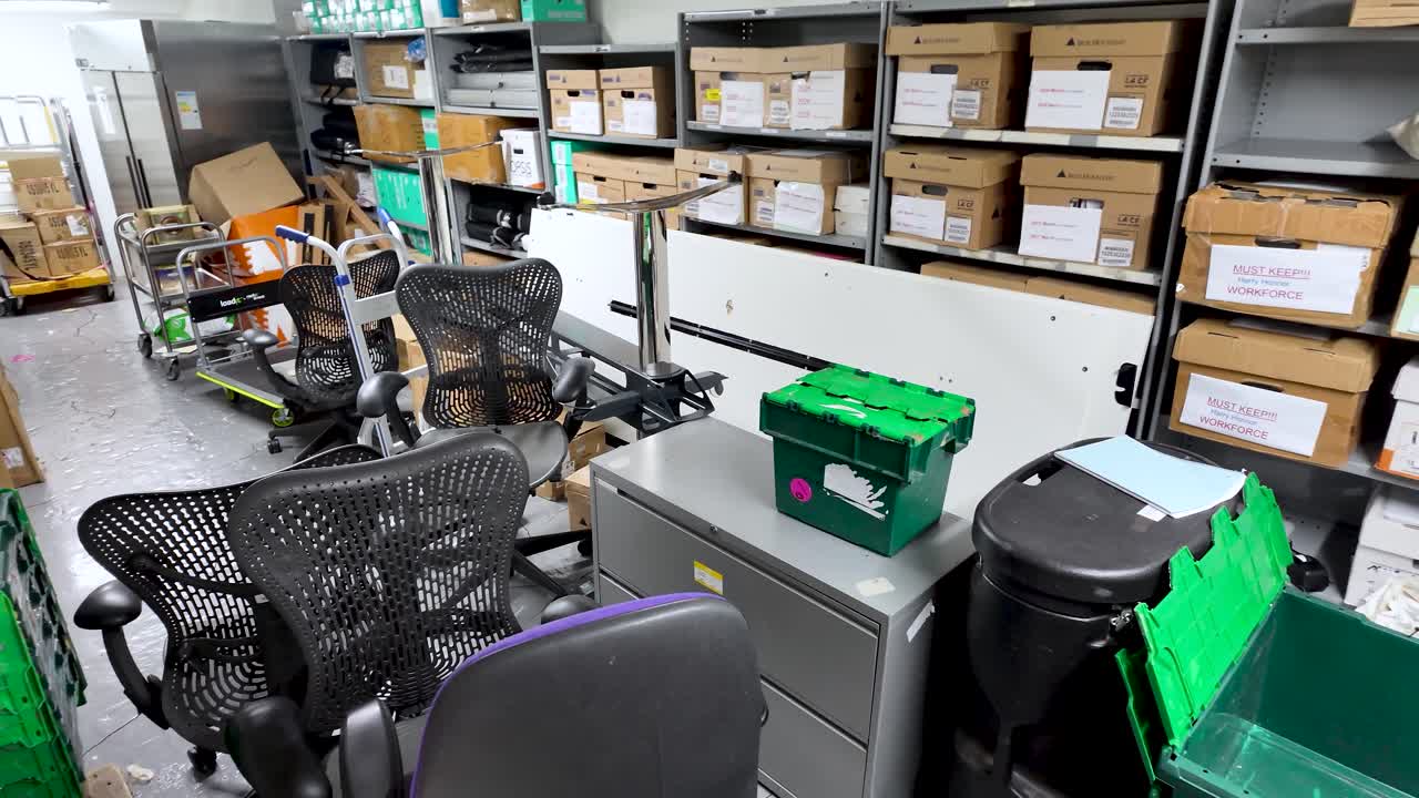 Office basement cluttered with chairs and storage boxes