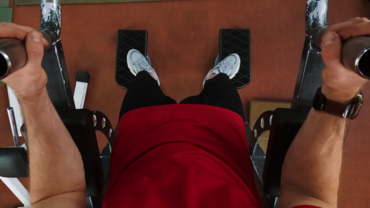 Person performing leg press exercise at the gym, first-person view