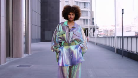 Woman in Futuristic Iridescent Outfit on Urban Sidewalk