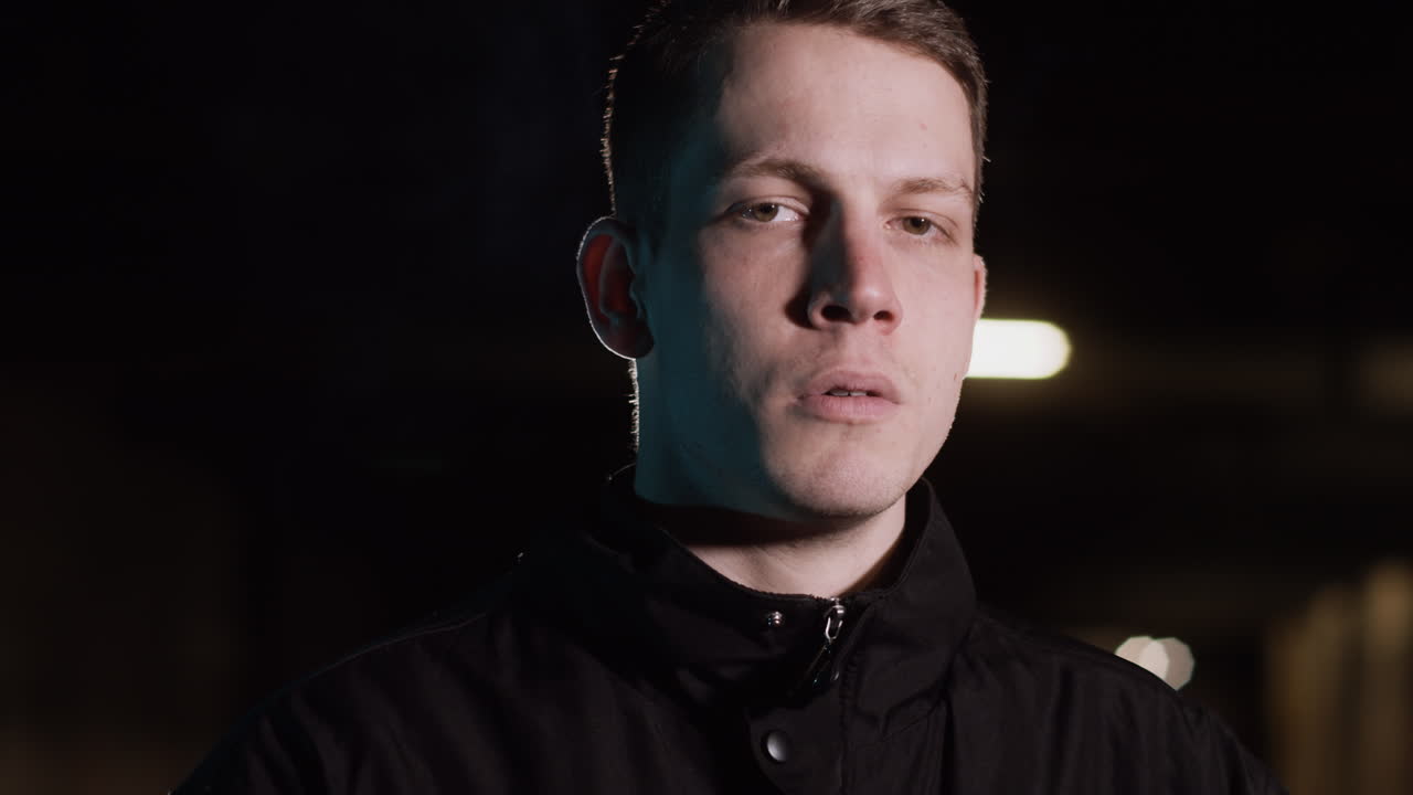 Man Smoking in Underground Parking Garage at Night