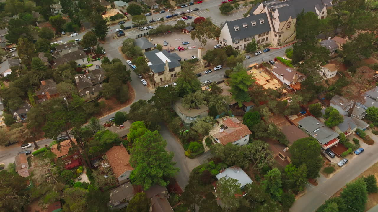 Cozy dwellings and fine streets of Carmel-by-the-Sea, California, USA. Drone footage over the American city at daytime. Bird's eye view.