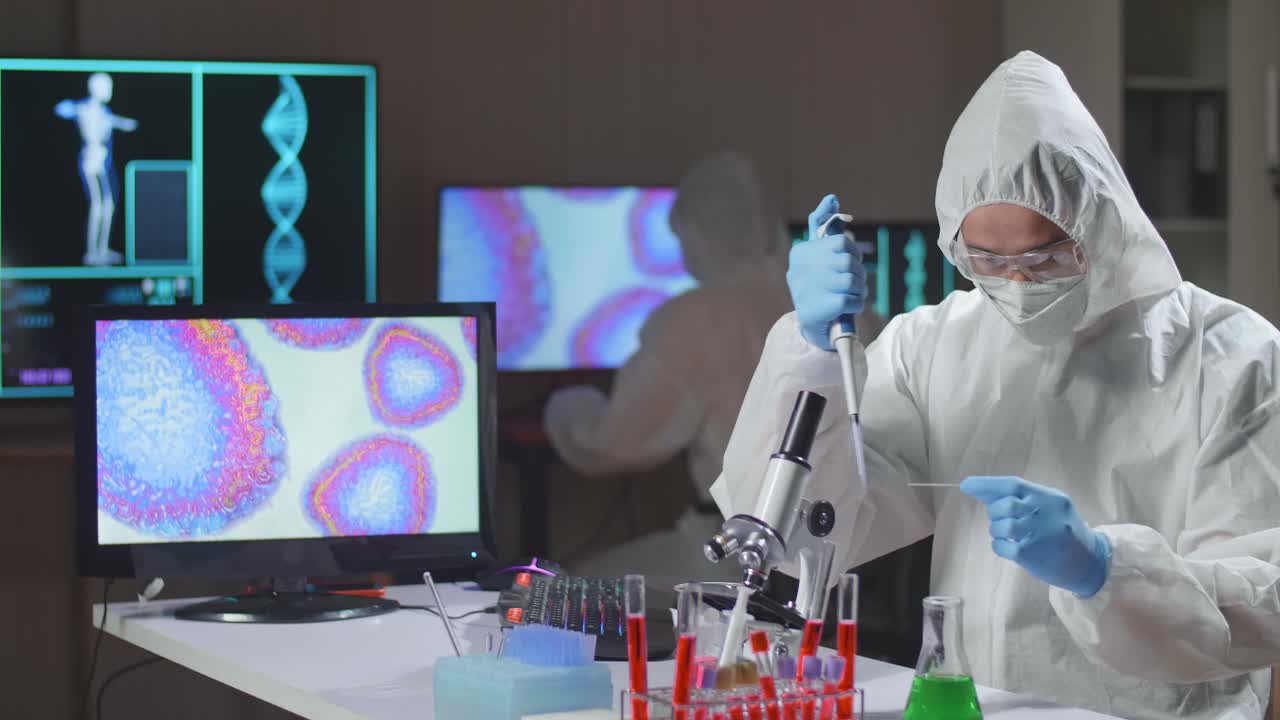 Asian Doctor In Protective Suit Is Doing A Science Experiments And Developing Vaccine In A Modern Lab. Laboratory Assistant Workplace. The Concept Of Science And Medicine