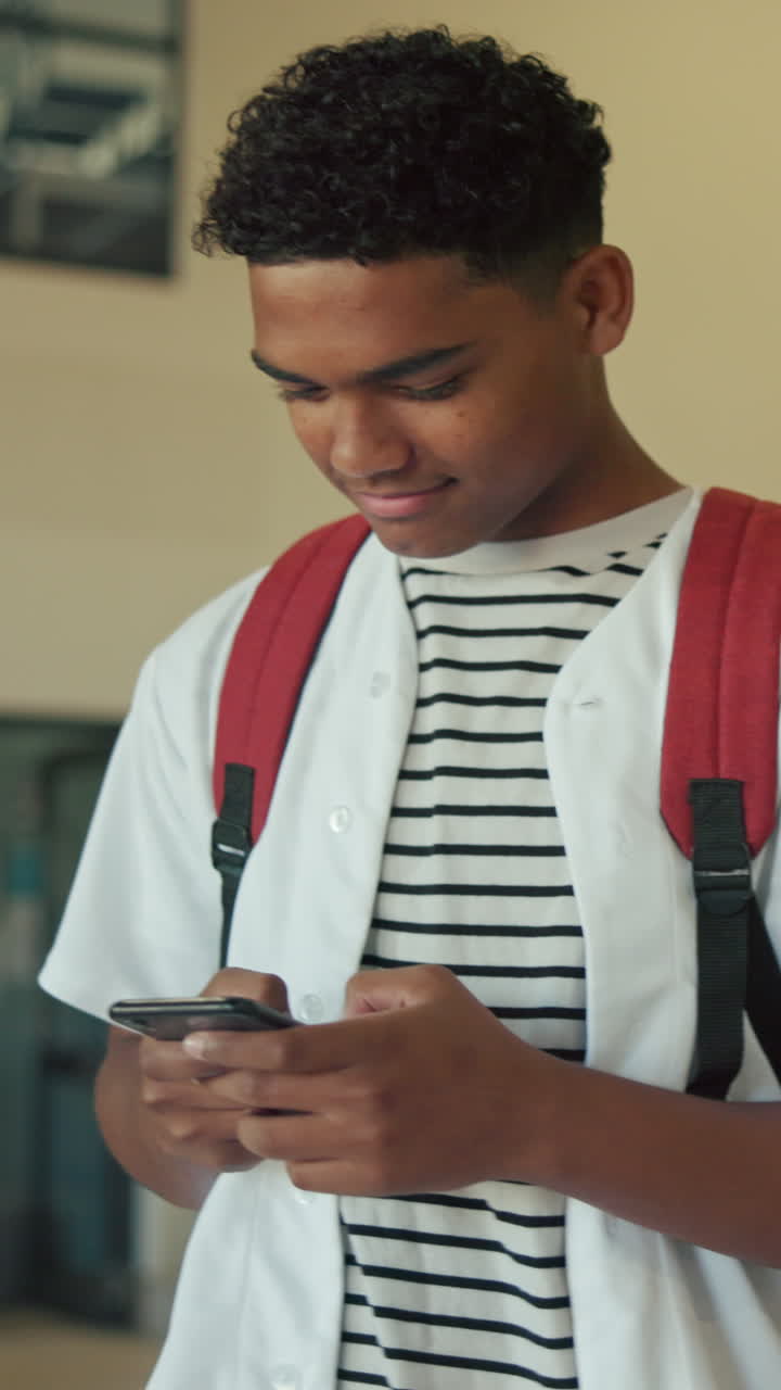 Young Man Texting on Smartphone with Backpack