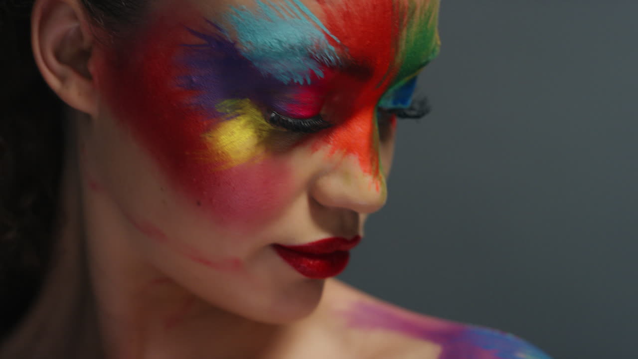retrato de cerca de una mujer hermosa con una pintura de rostro colorida arte corporal multicolor exótico mujer sensual que disfruta de la expresión creativa