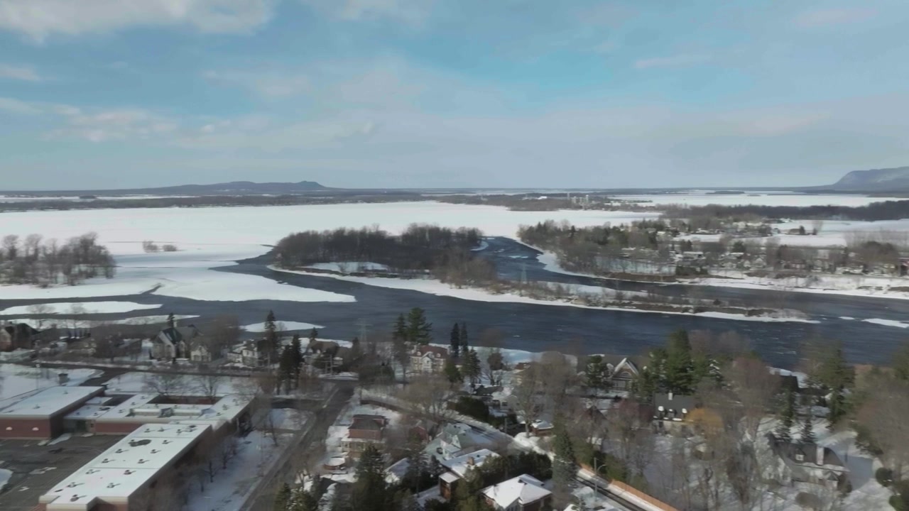 drone hampir melakukan rotasi 360 derajat yang menunjukkan bagian tertua kota Chambly di Quebec, Kanada, pada musim dingin dari jembatan menuju Benteng Chambly