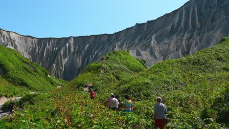 hiking through a valley with gray cliffs