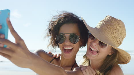 Two-friends-taking-selfies-on-the-beach