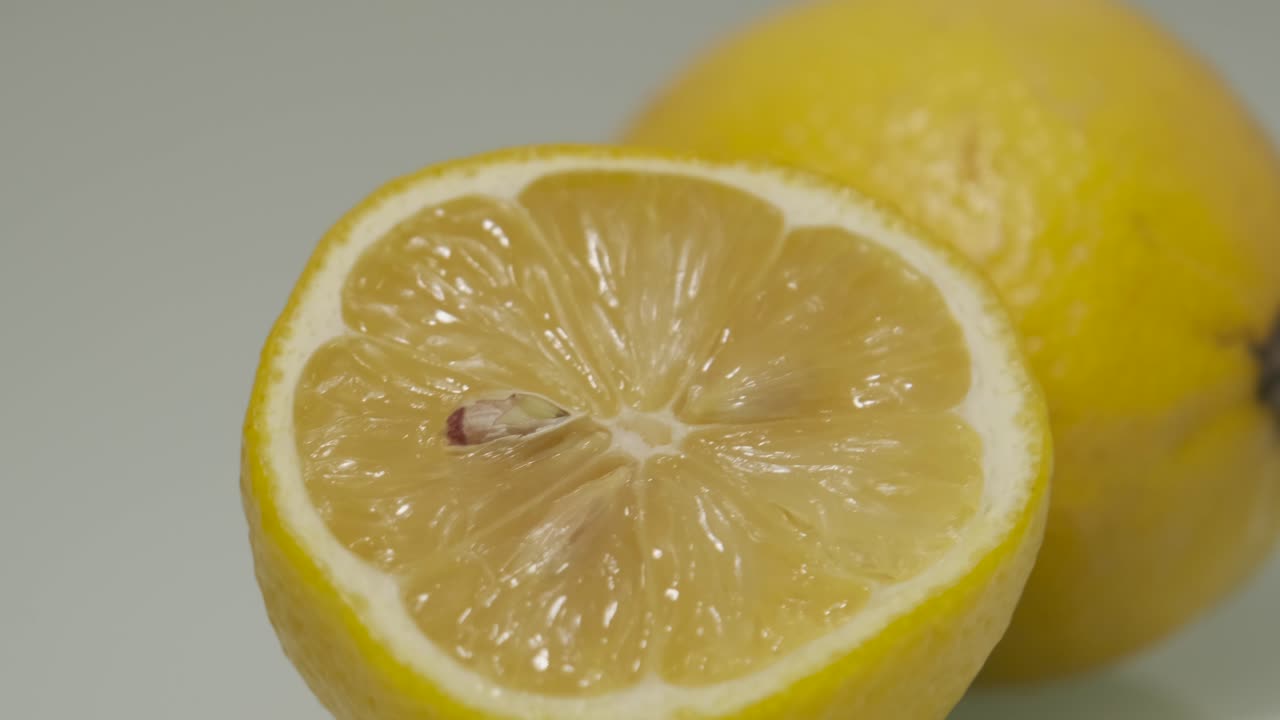 сочный свежесрезанный лимон с желтой кожурой и белой кожурой панорамирование справа налево с вращающимся освещением обстановки