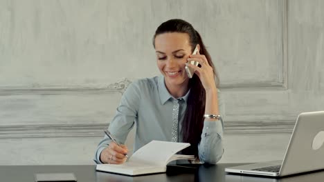 mujer de negocios feliz hablando por teléfono celular en una oficina moderna