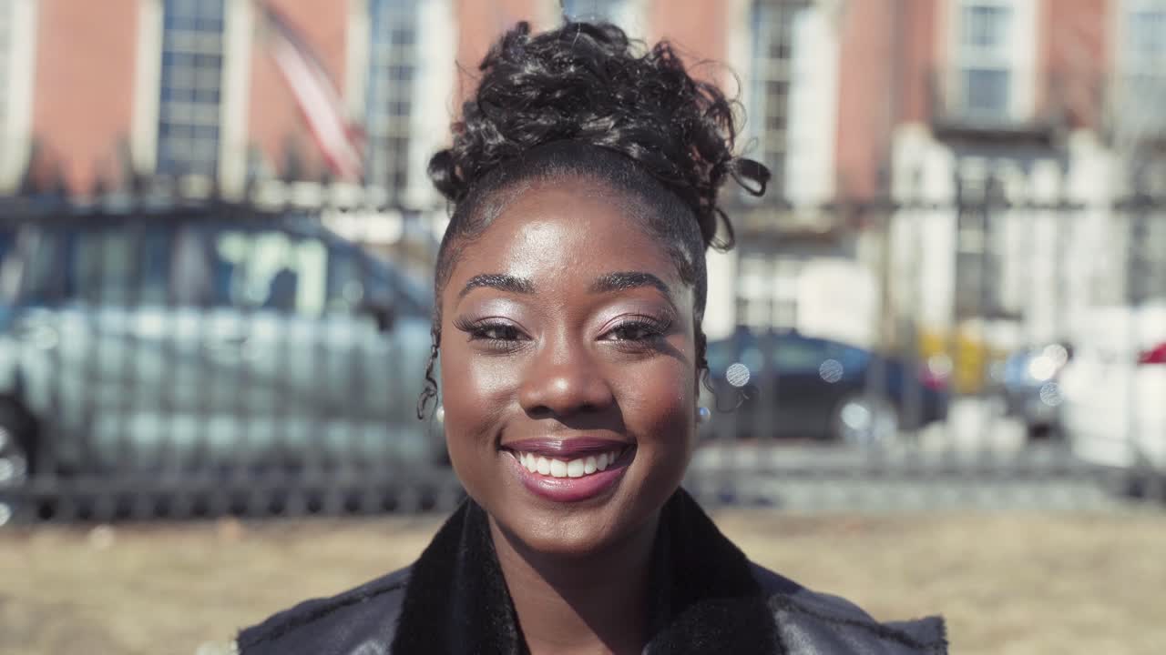 Portrait of Beautiful Stylish African American Woman With Makeup Smiling At Camera With Confidence On A Sunny Day In The City, Wearing Black Clothes, Close Up Shot