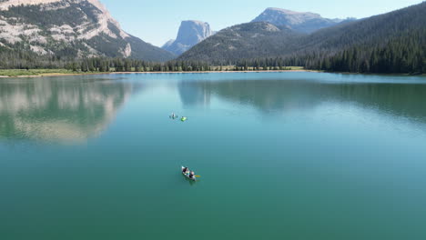 tourists canoeing on lower green river lakes with scenic mountains at background in wyoming