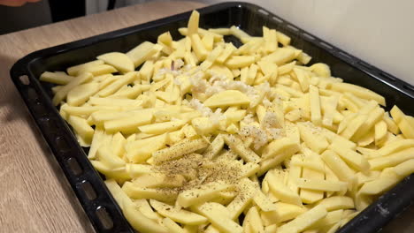 parrilla de tiro cercano con patatas francesas crudas cortadas mano agrega pimienta y las mezcla