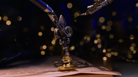 surgical robotic equipment takes a metal stamp. da vinci futuristic robot makes a seal on the letter. dark blurred backdrop with lights.