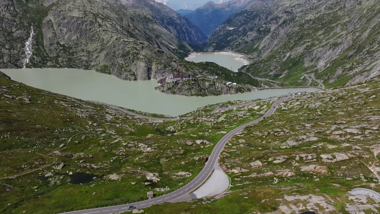Aerial View of a Winding Mountain Road and Alpine Lake in the Swiss Alps