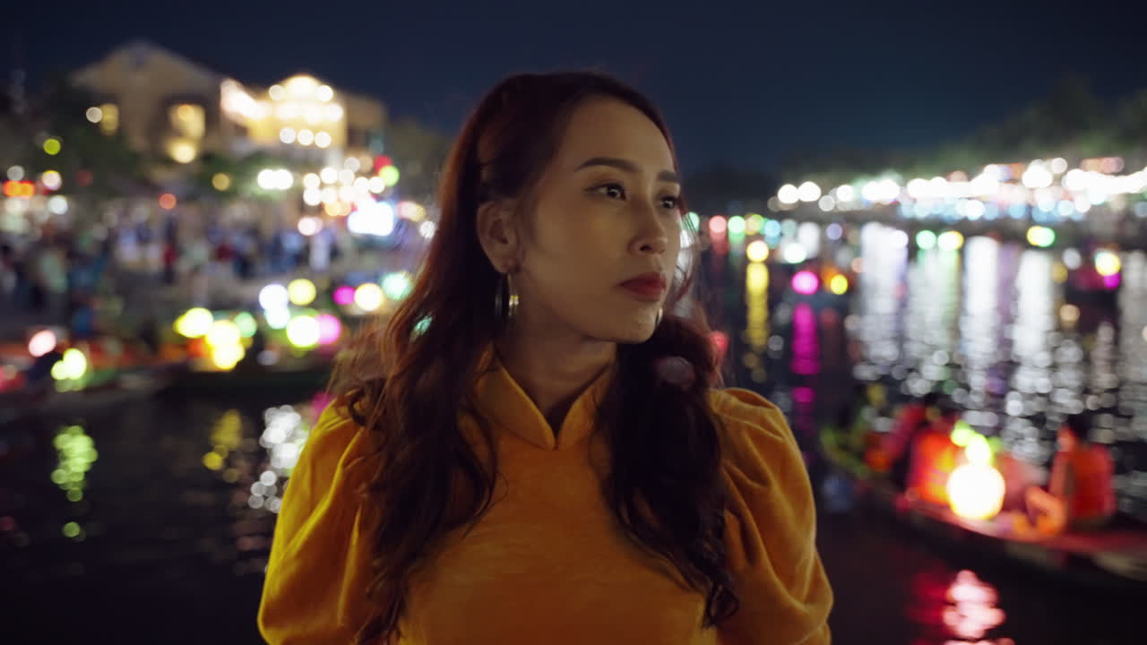 расстроенная женщина ищет кого-то, потерянного на улицах хой-ана ночью.