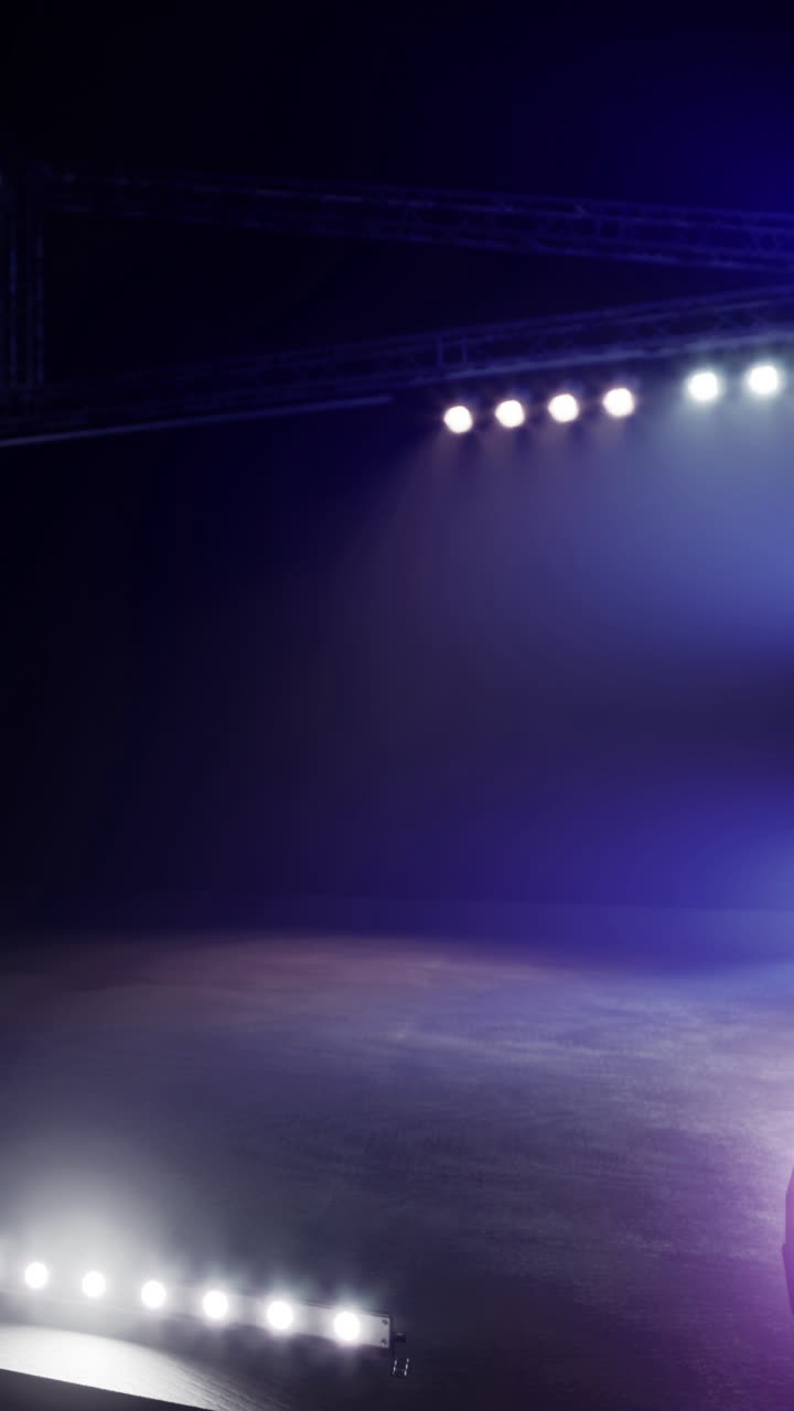 Stage lights shine brightly during a performance in a theater at night