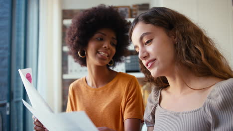 dos jóvenes compañeras de negocios con documentos que se reúnen en la oficina