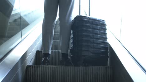 low angle view of businessman with suitcase on escalator