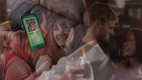 Composition-of-woman-holding-a-smartphone-with-qr-code-on-screen-against-multiple-couples-on-a-date