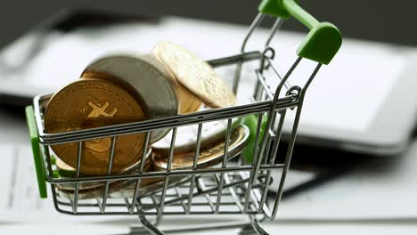 miniature shopping cart filled with digital and regular coins