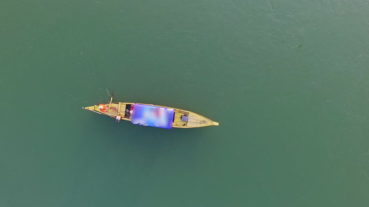 Man Rowing While Standing On His Boat Across Mekong River In Kompong Khleang, Cambodia - Aerial Shot