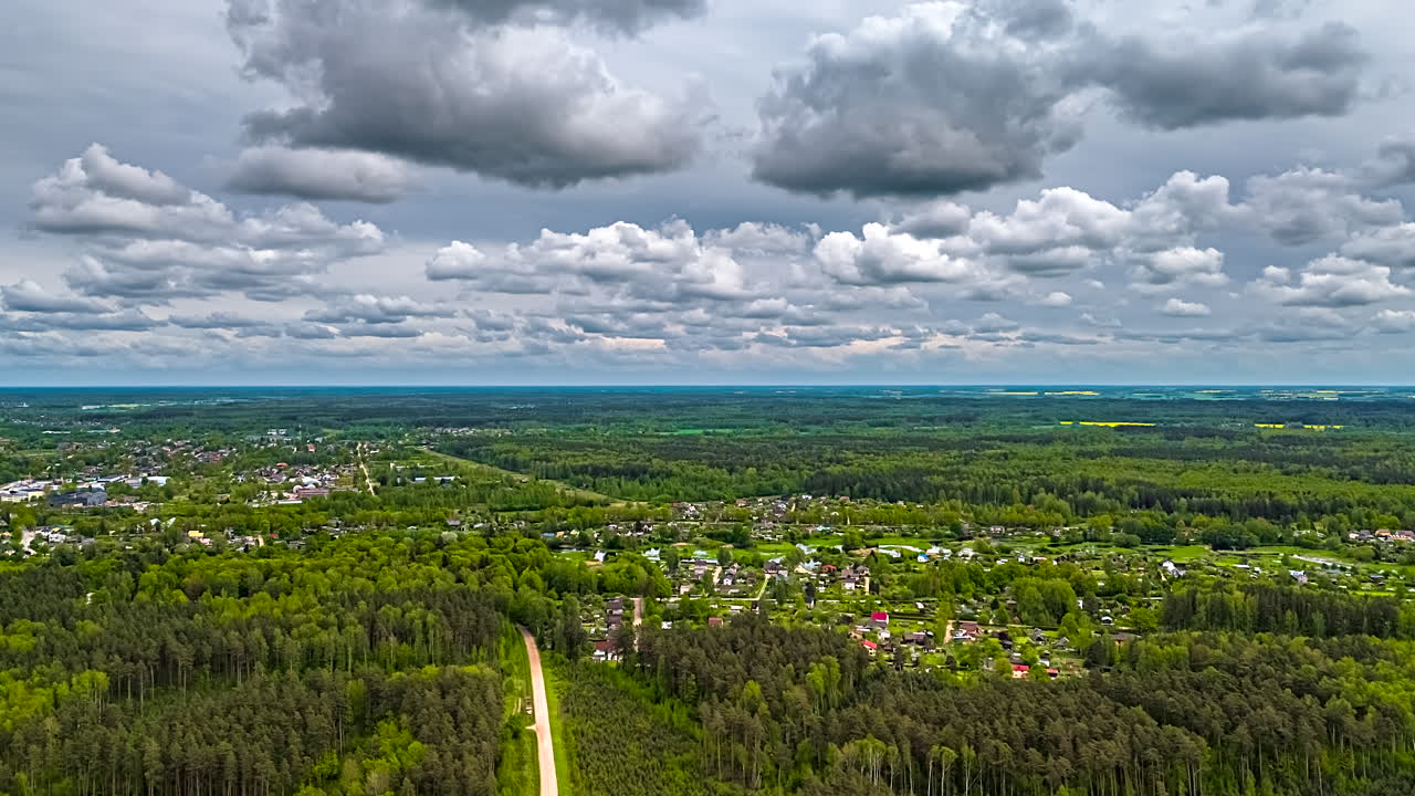 Green woodland landscape with township, aerial time lapse view