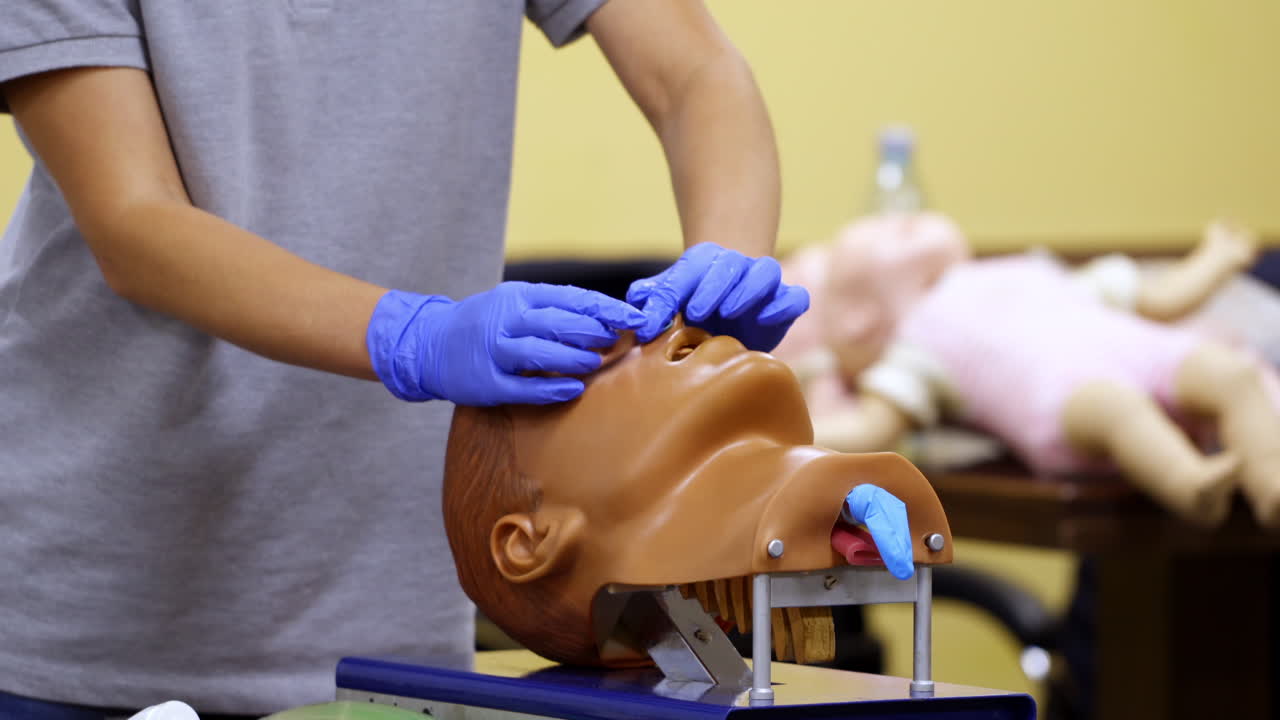 Medic conducts medical teaching. Instructor teaching practical technologies on a dummy head in medical center.