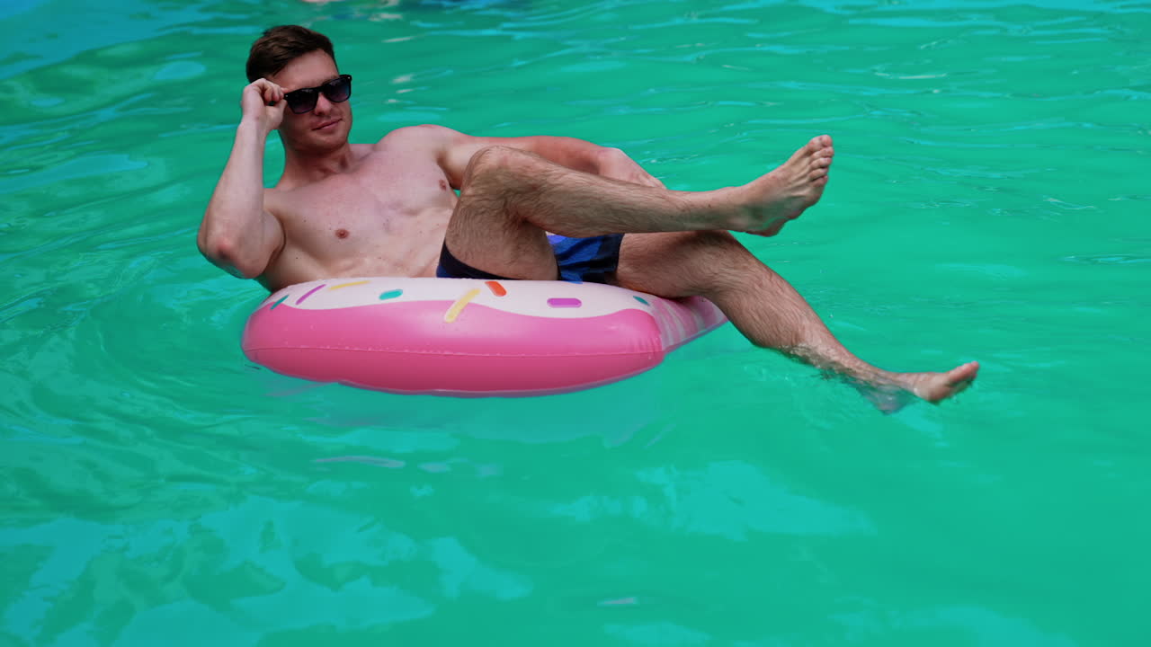 Man relaxing on a donut pool float