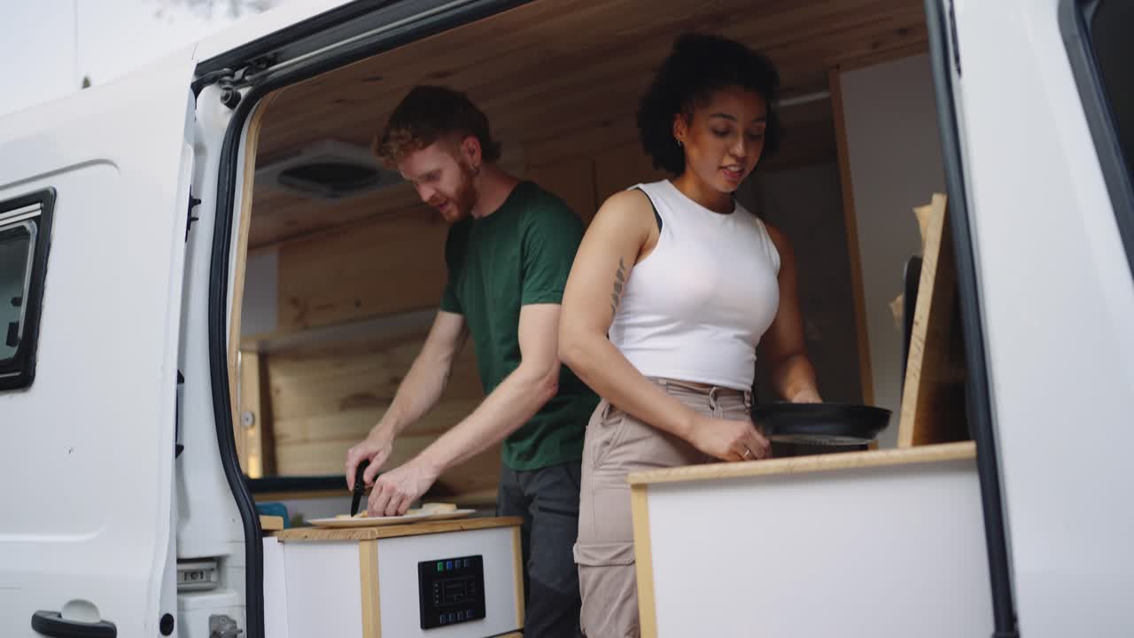 Couple cooking in their campervan