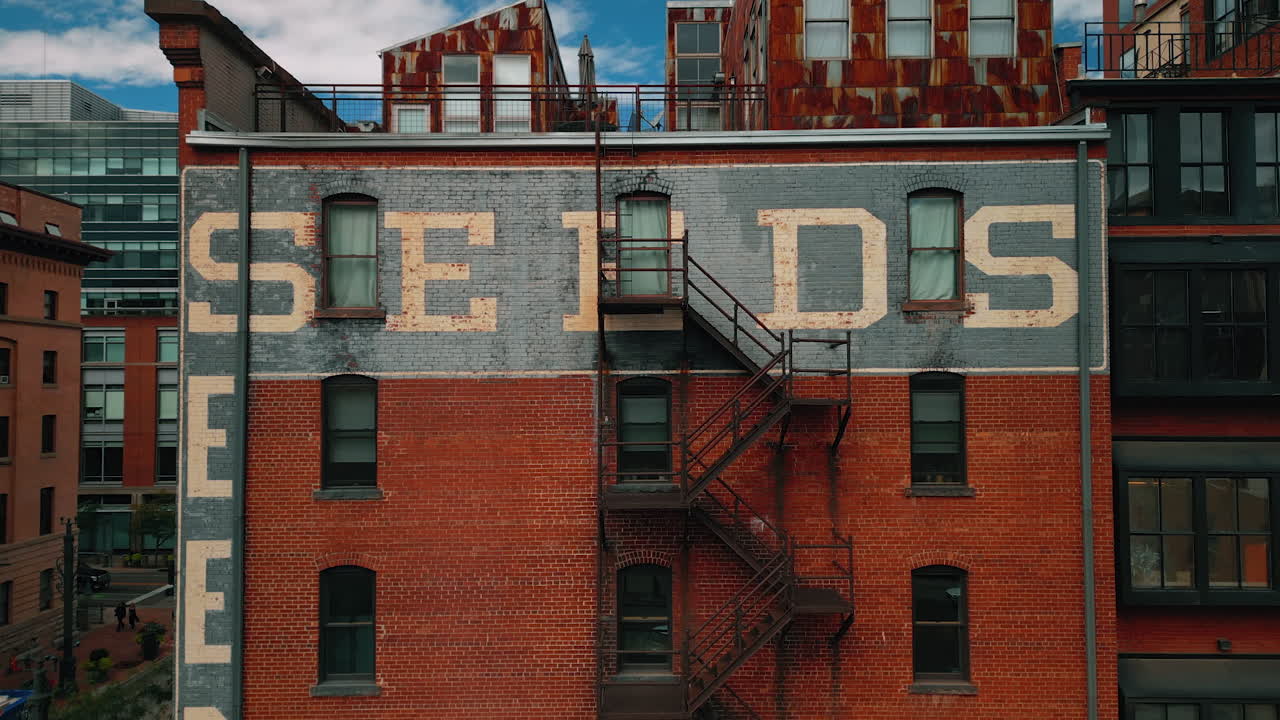 Denver, USA, 28 July 2025: Descending along the façade of a red-brick buildings with fire escape stairs. Architecture of modern Denver, Colorado, USA