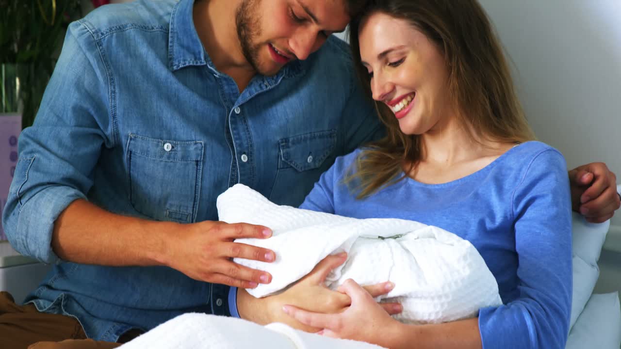 Couple with their newborn baby in ward