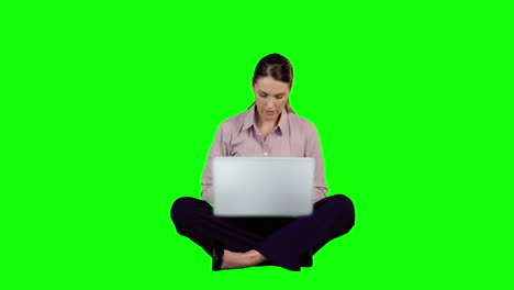 mujer de negocios usando portátil contra pantalla verde