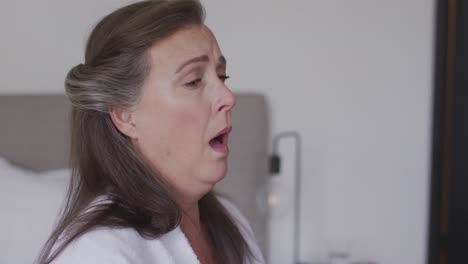 sick woman with tissue sneezing at home