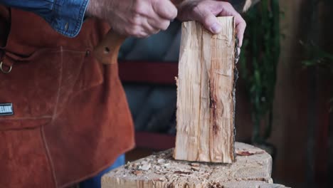 medium shot of craftsman cutting wood with hatchet