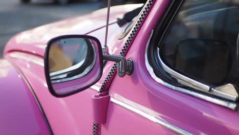 close-up of a pink vintage volkswagen beetle