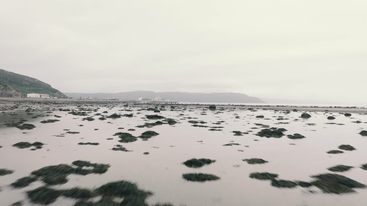 4K flying low towards port by the sea shore