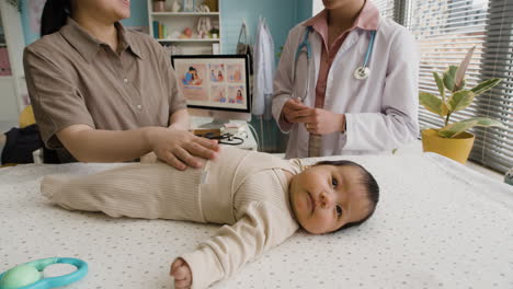 baby exam with doctor and mother