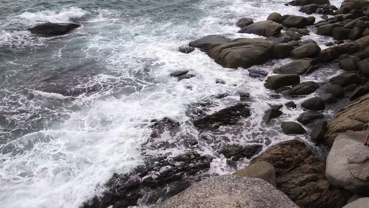 Le onde dell'oceano si schiantano contro la costa rocciosa