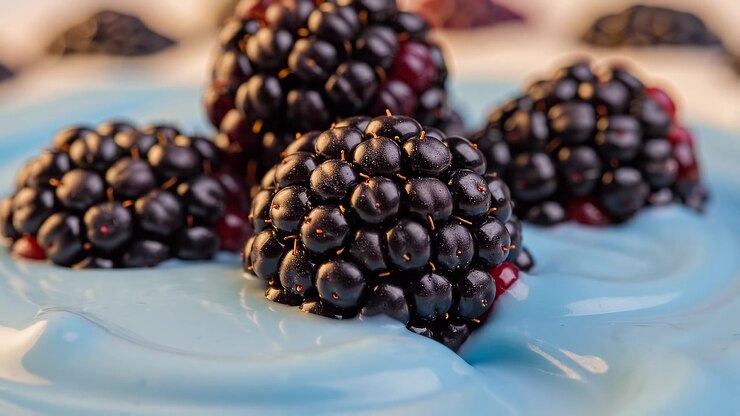 Fresh blackberries on smooth light blue creamy surface